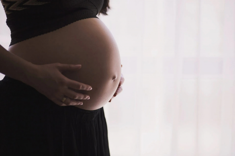 Mujer sujetándose el vientre durante su embarazo Mujer sujetándose el vientre durante su embarazo