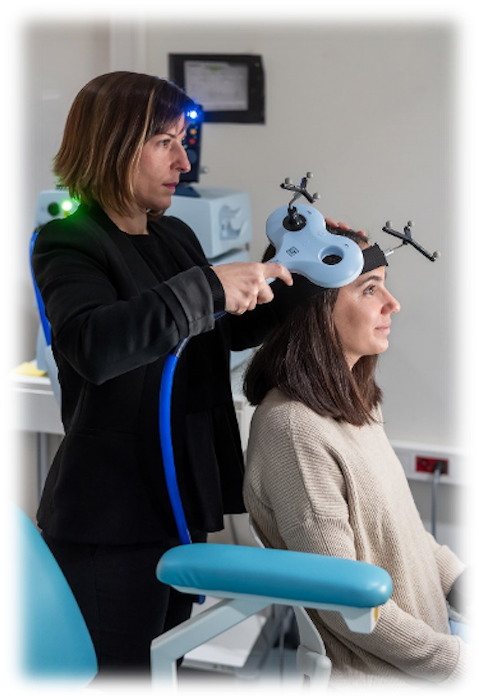 La imagen muestra a una Investigadora utilizando la TMS para estimular el cortex cerebral de una participante.